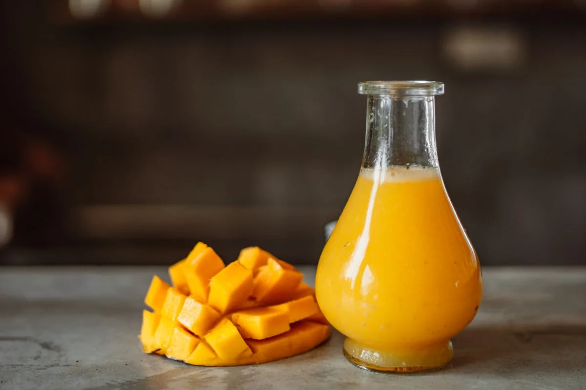 Mango drink in a bottle beside cut mango